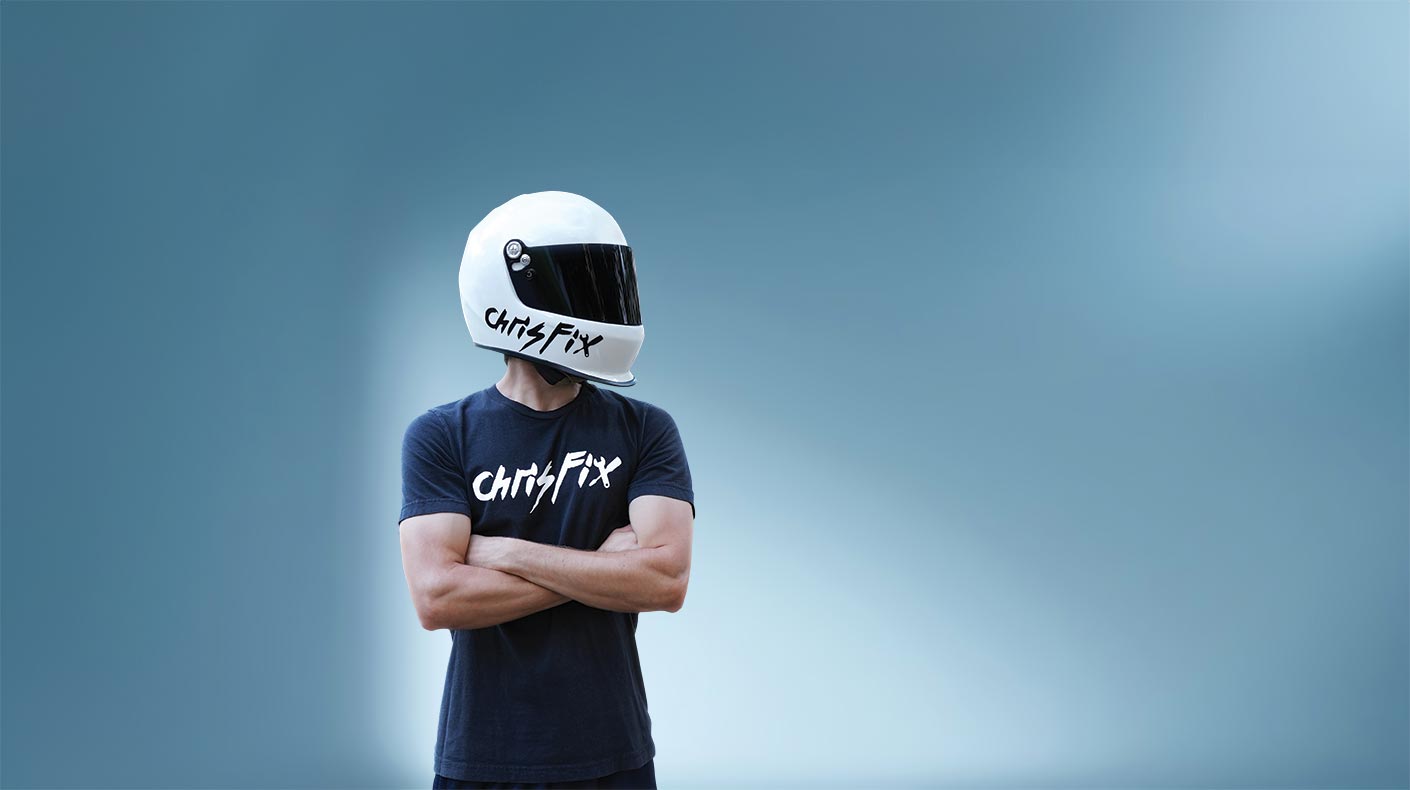 Chris Fix with helmet on standing with arms folded