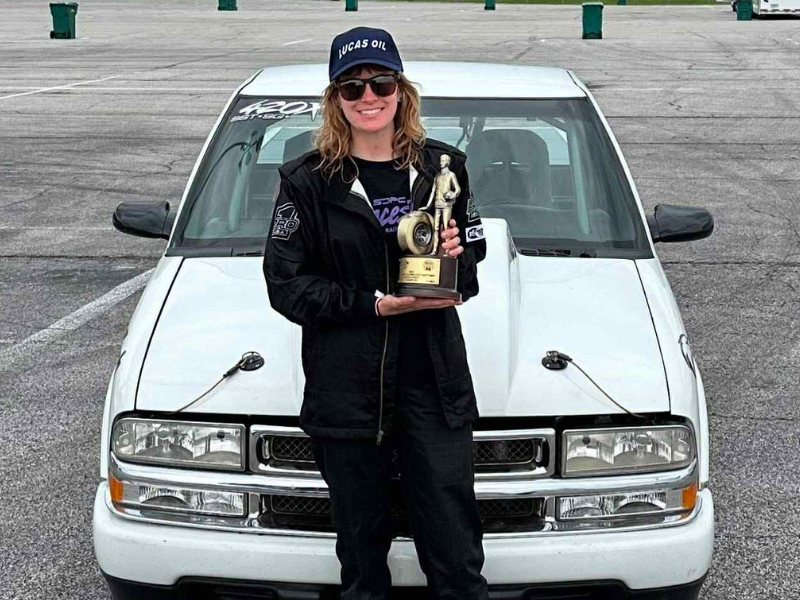 Bailey Estes-Alonzo standing in front of her Chevy S10 with her trophy