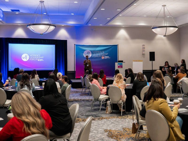 attendee listen to presentation and Women's Leadership Forum