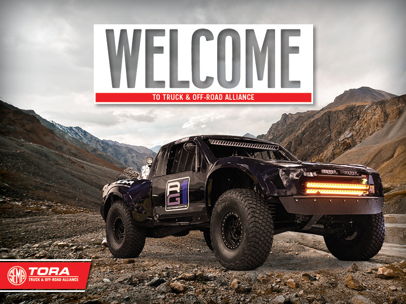 Off-Road truck with stark mountain range in background with "Welcome" overliad