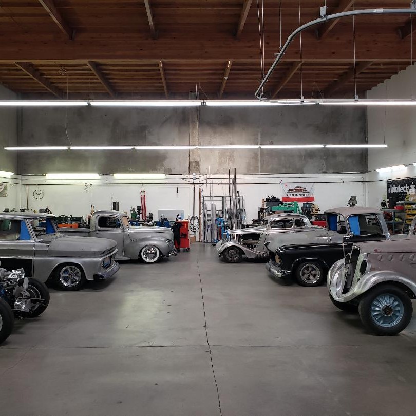 Various hot rods parked in a garage shop