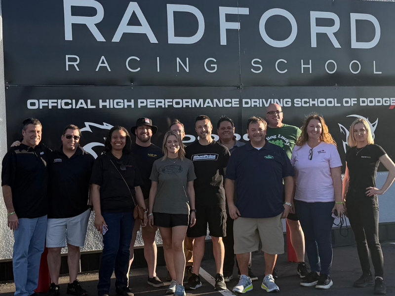Group photo of MPMC Select Committee in front of Radford Racing School sign