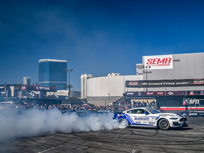 An image of a Mustang drifting the outside of the SEMA Show.