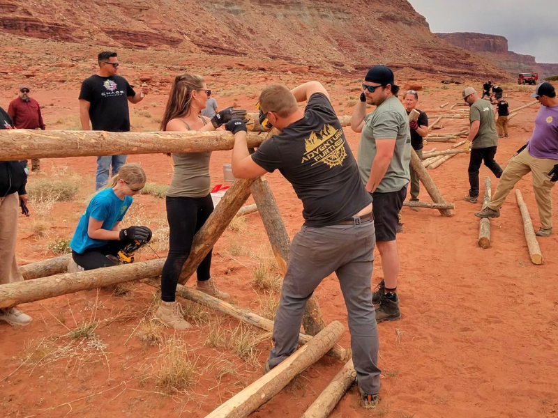 Volunteers repairing fencing along an off-road trail