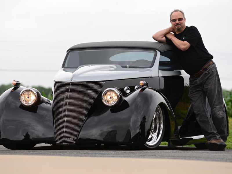 Edward Denkenberger leaning on a hot rod