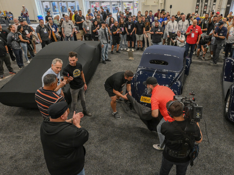 People gathered around a featured vehicle in a booth