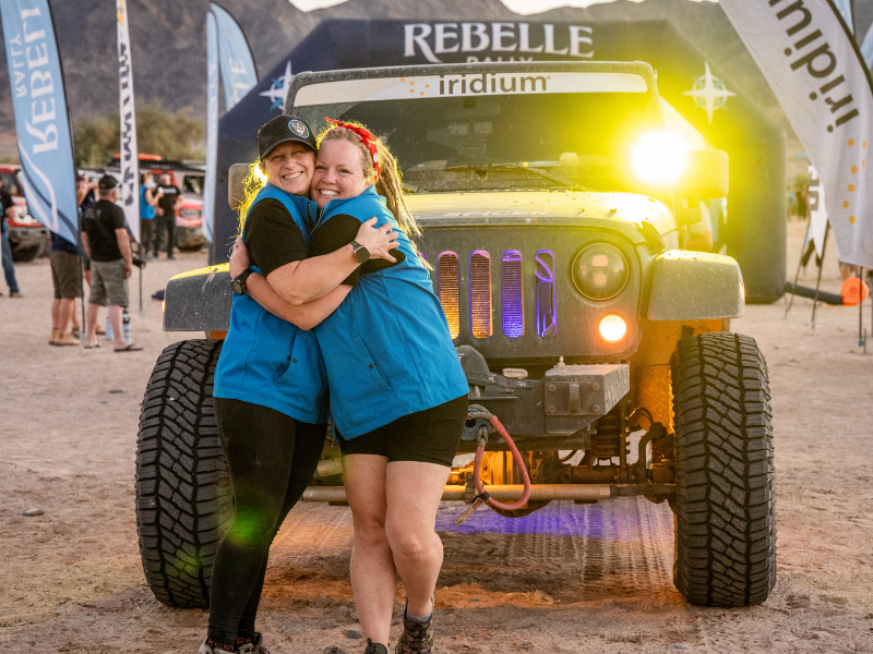 Keri Porter standing in front of her Jeep hugging a friend at the Rebelle Rally