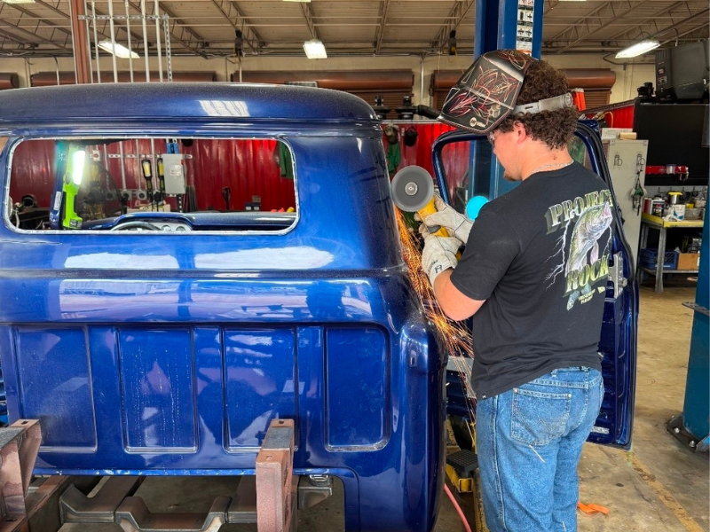 Guy using a cutting tool on a truck being restored.
