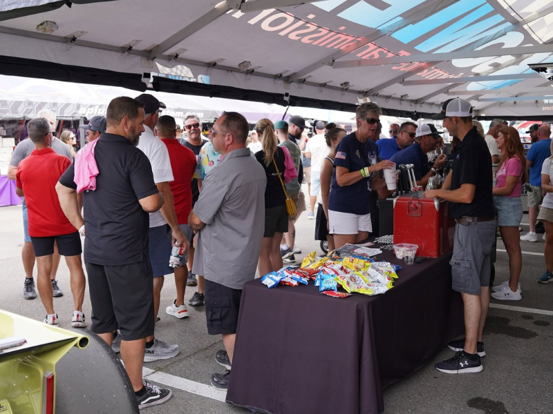 Folks enjoying happy hour under a tent