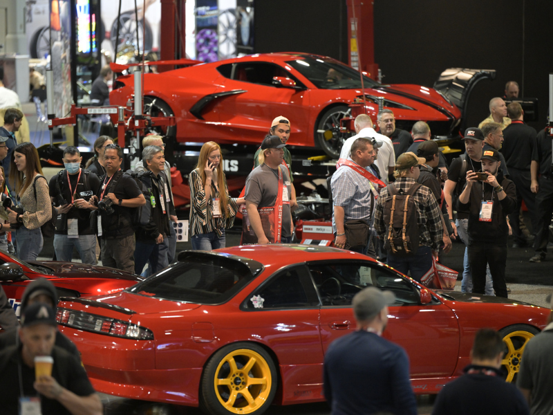 People looking at cars in booth in the South Hall of the SEMA Show
