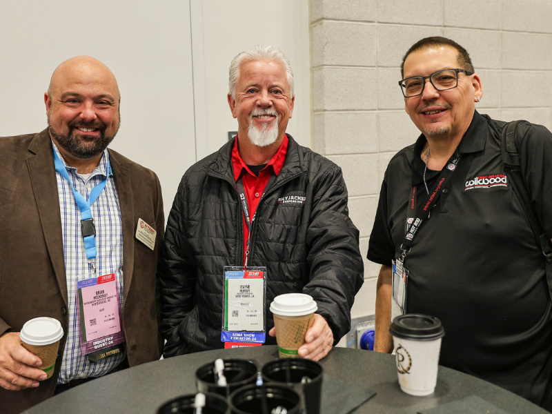 Men standing around table having coffee