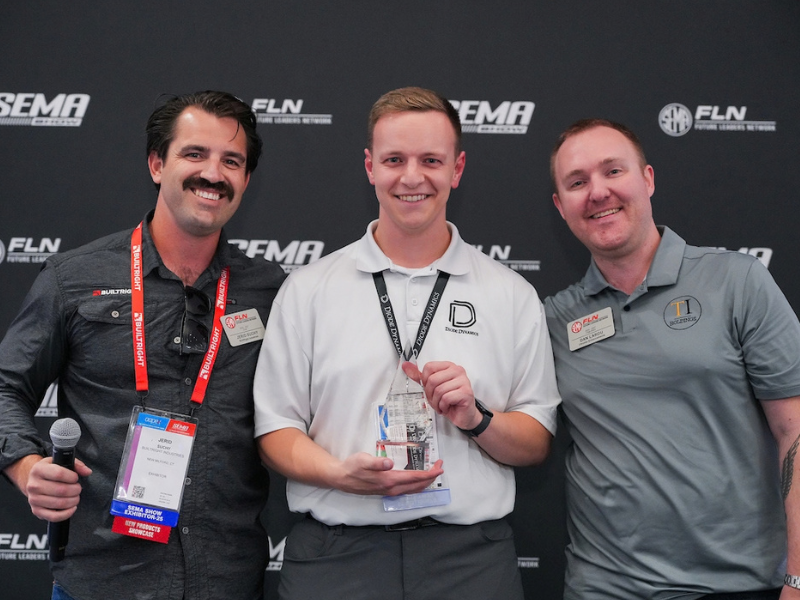 Jordan Mosher smiling his FLN 2025 Professional of the Year award with two other men 