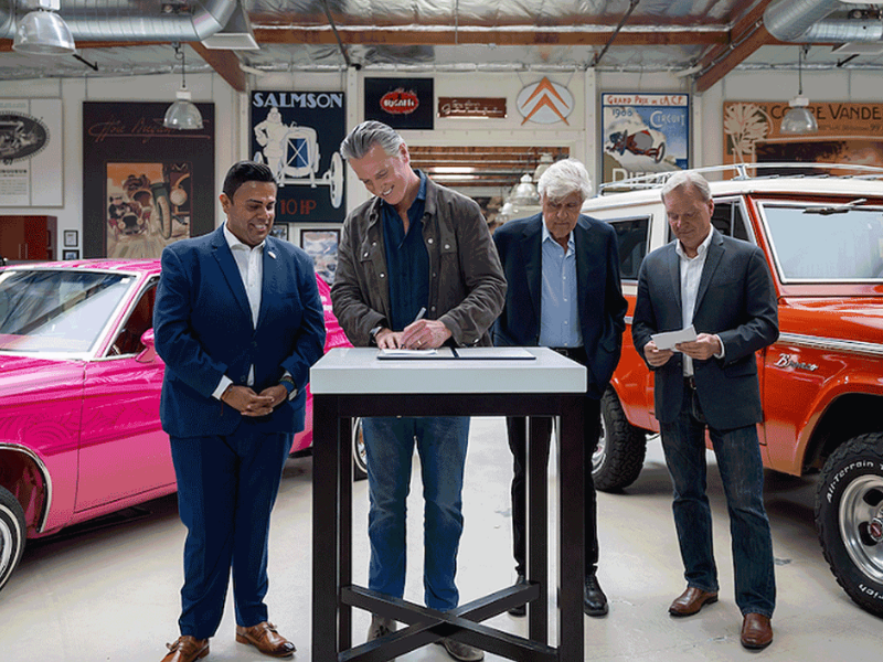 California Gov. Gavin Newsom signs "Leno's Law" with Jay Leno looking on.