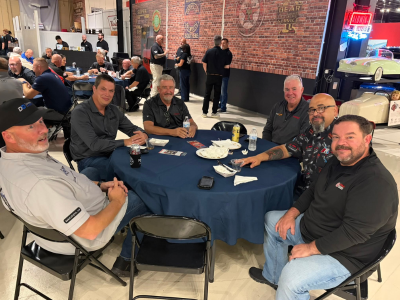 Attendees sit around a table at SEMA Fuel Your Future