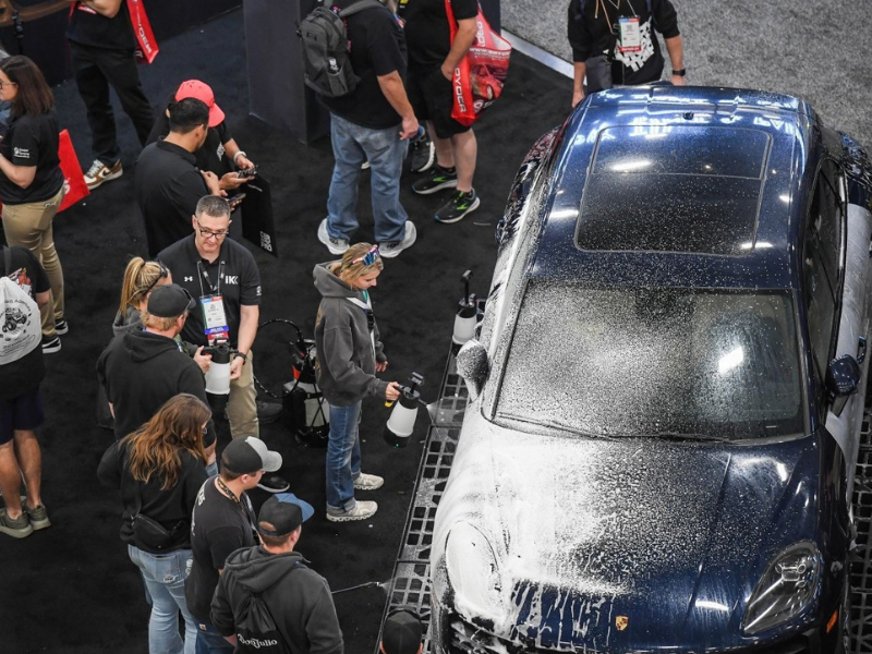 People watch product demonstration at a booth at the SEMA Show