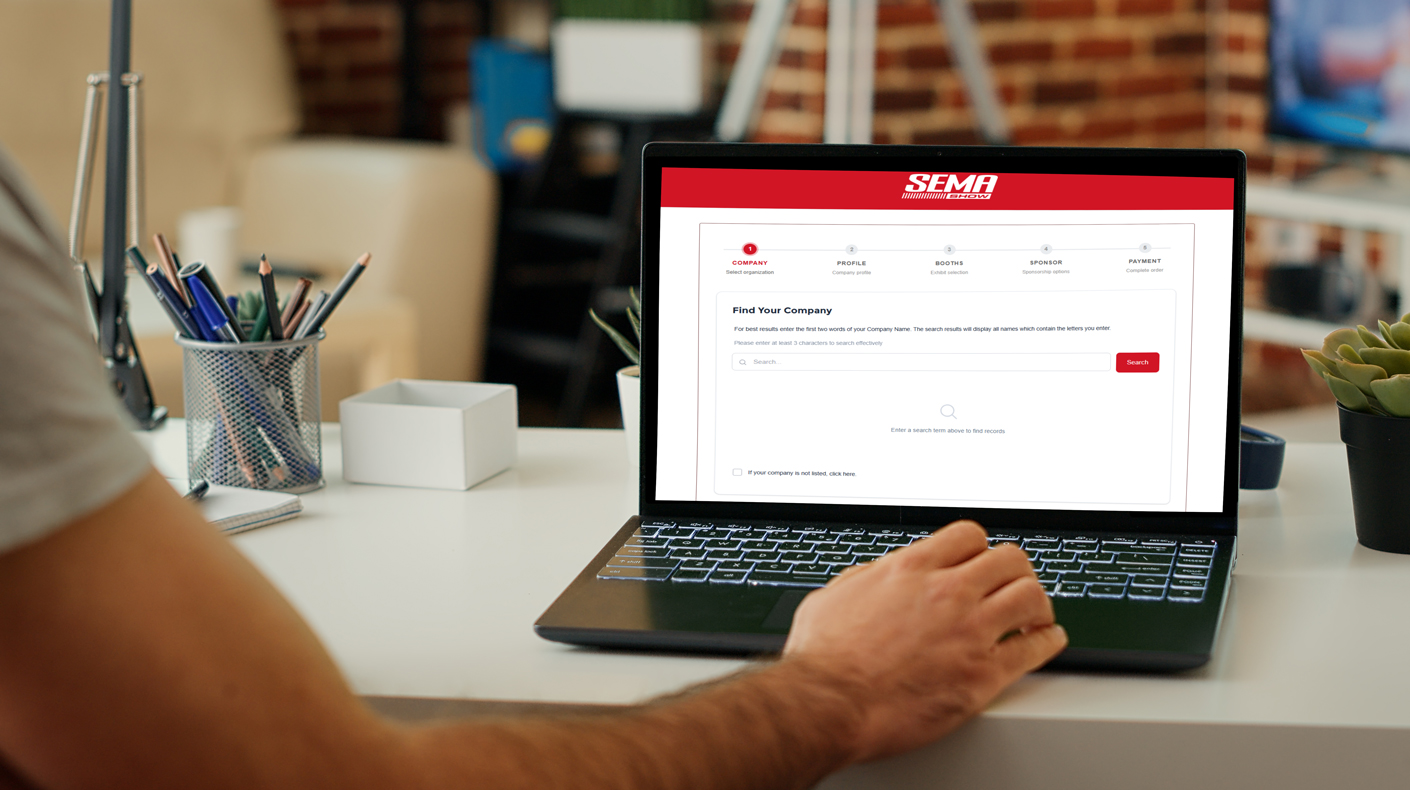Person using a laptop with the SEMA Show exhibitor portal webpage pulled up. Courtesy of Shutterstock