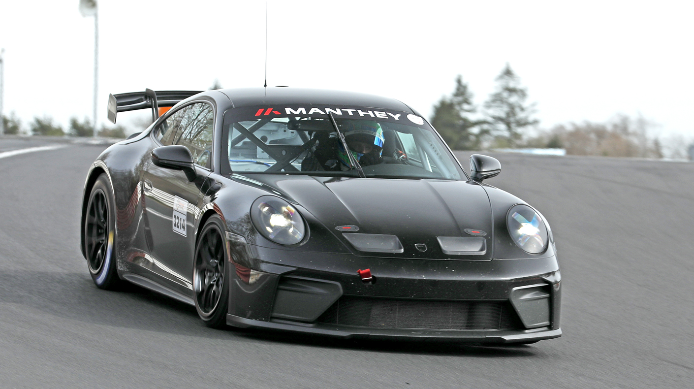 A camouflaged Porsche 911 GT4 on the track.
