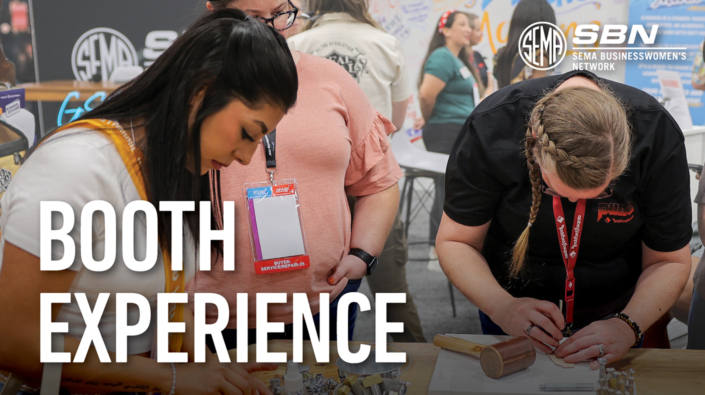 Women working on an activity in the SBN Booth at the SEMA Show.