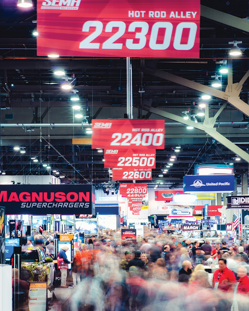 A timelapse photo of a crowded aisle on the SEMA Show floor.