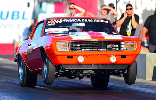 An orange Camaro at an NMCA event