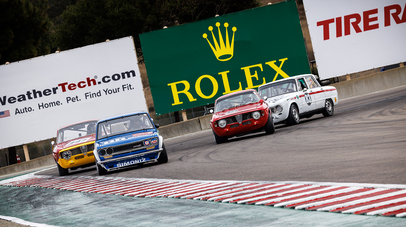 A photo of small, vintage, European cars racing at WeatherTech Raceway Laguna Seca.