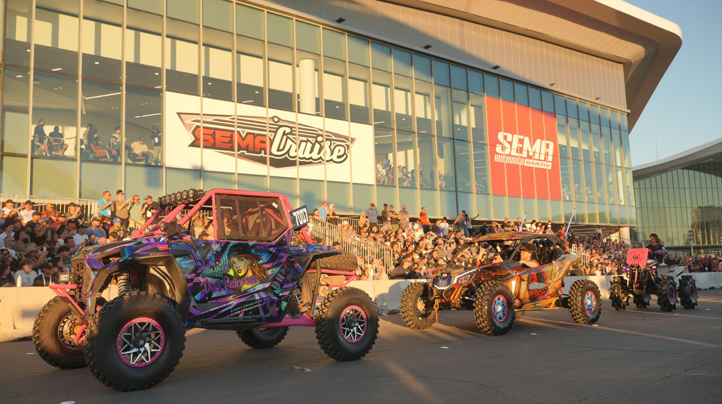 Powersports vehicles driving along the exterior of the Las Vegas Convention Center during the 2025 SEMA Cruise.