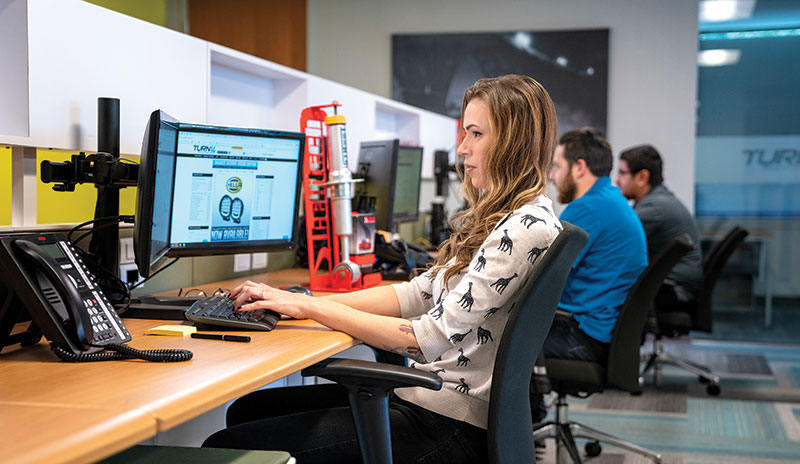 Turn 14 employee typing on a computer
