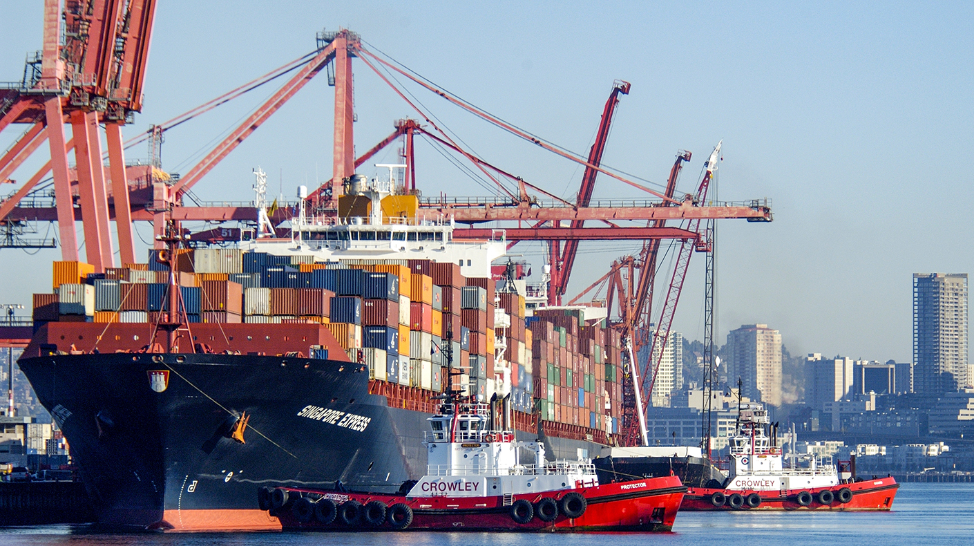 Photo of a freighter loaded with cargo docked at port.
