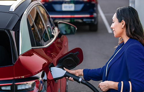A woman plugging in an EV