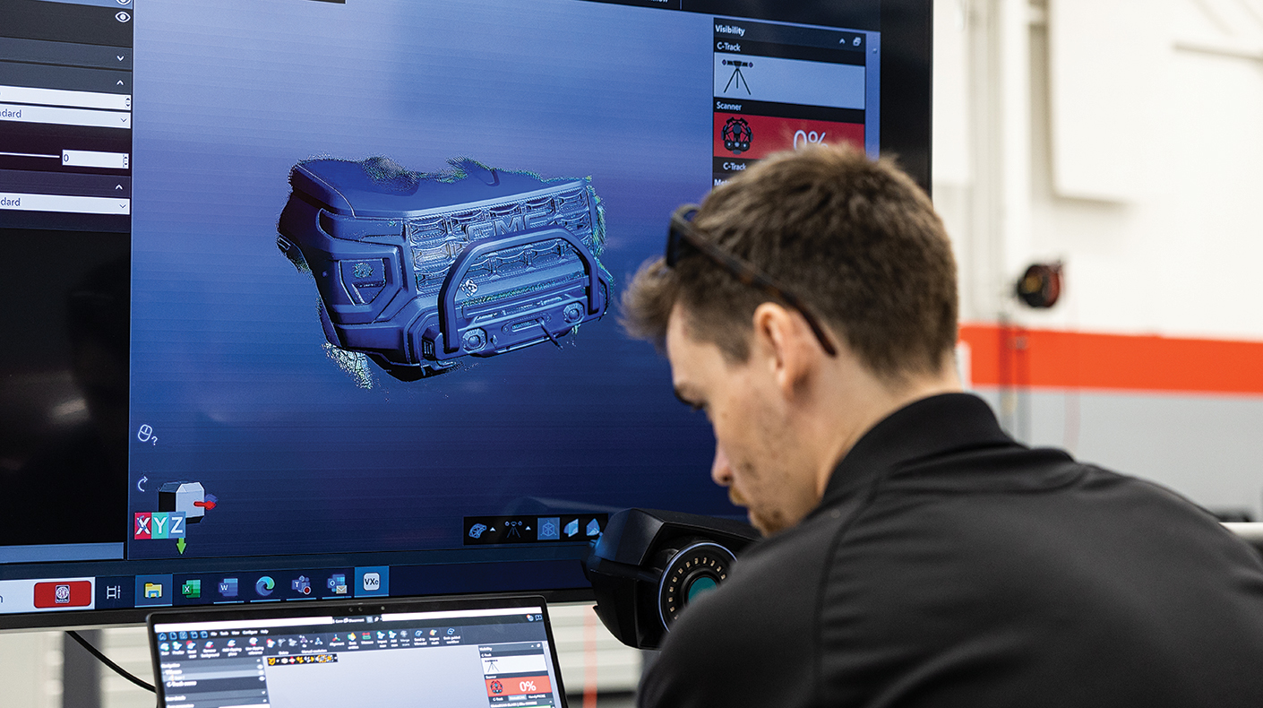 A SEMA Garage staffer looking at 3D scans of a vehicle. 