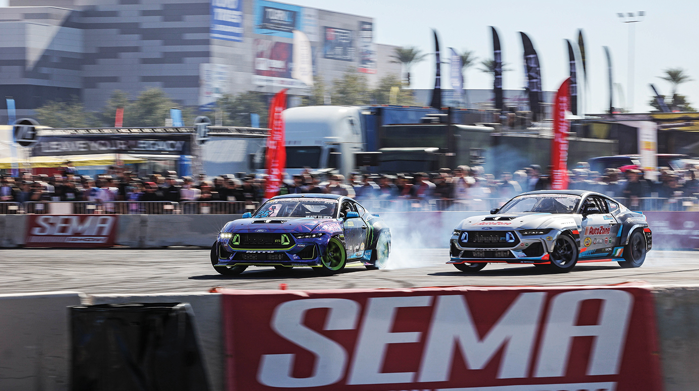 Two cars drifting outside the front of the SEMA Show.