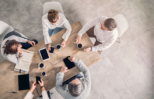 A group of people sitting around a table with coffee
